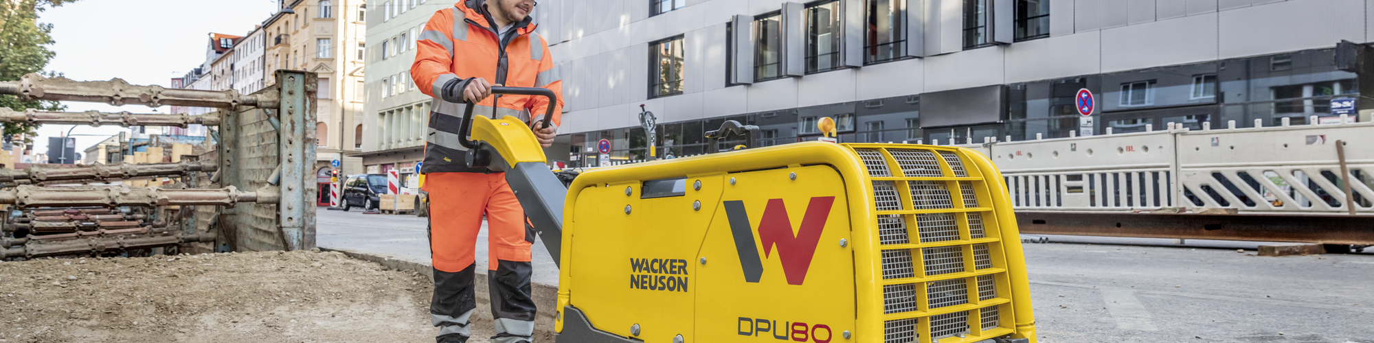 A Wacker Neuson vibratory plate in action on a construction site in the city.